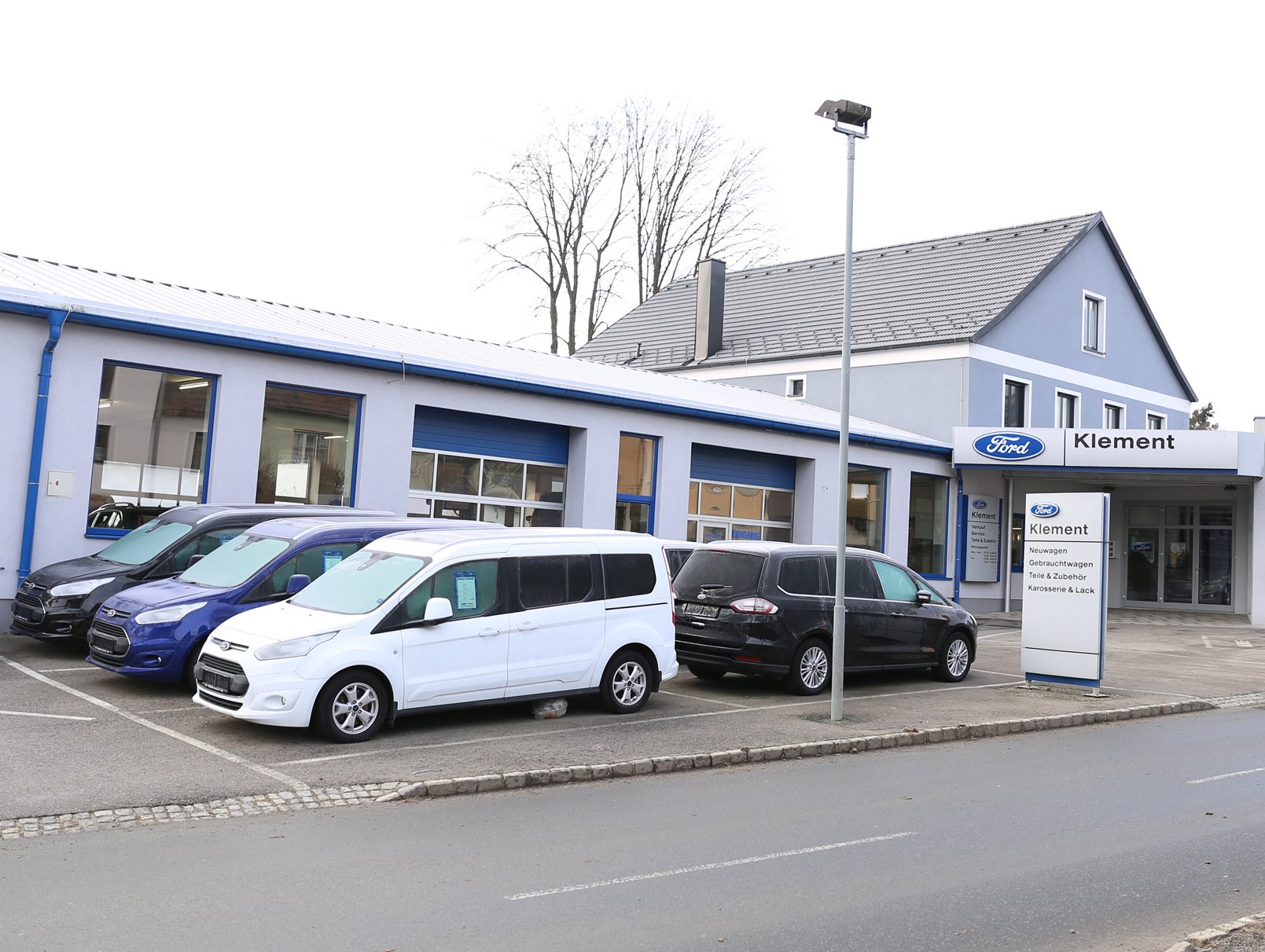 Außenansicht des Ford Autohauses Klement mit mehreren Fahrzeugen auf dem Parkplatz.