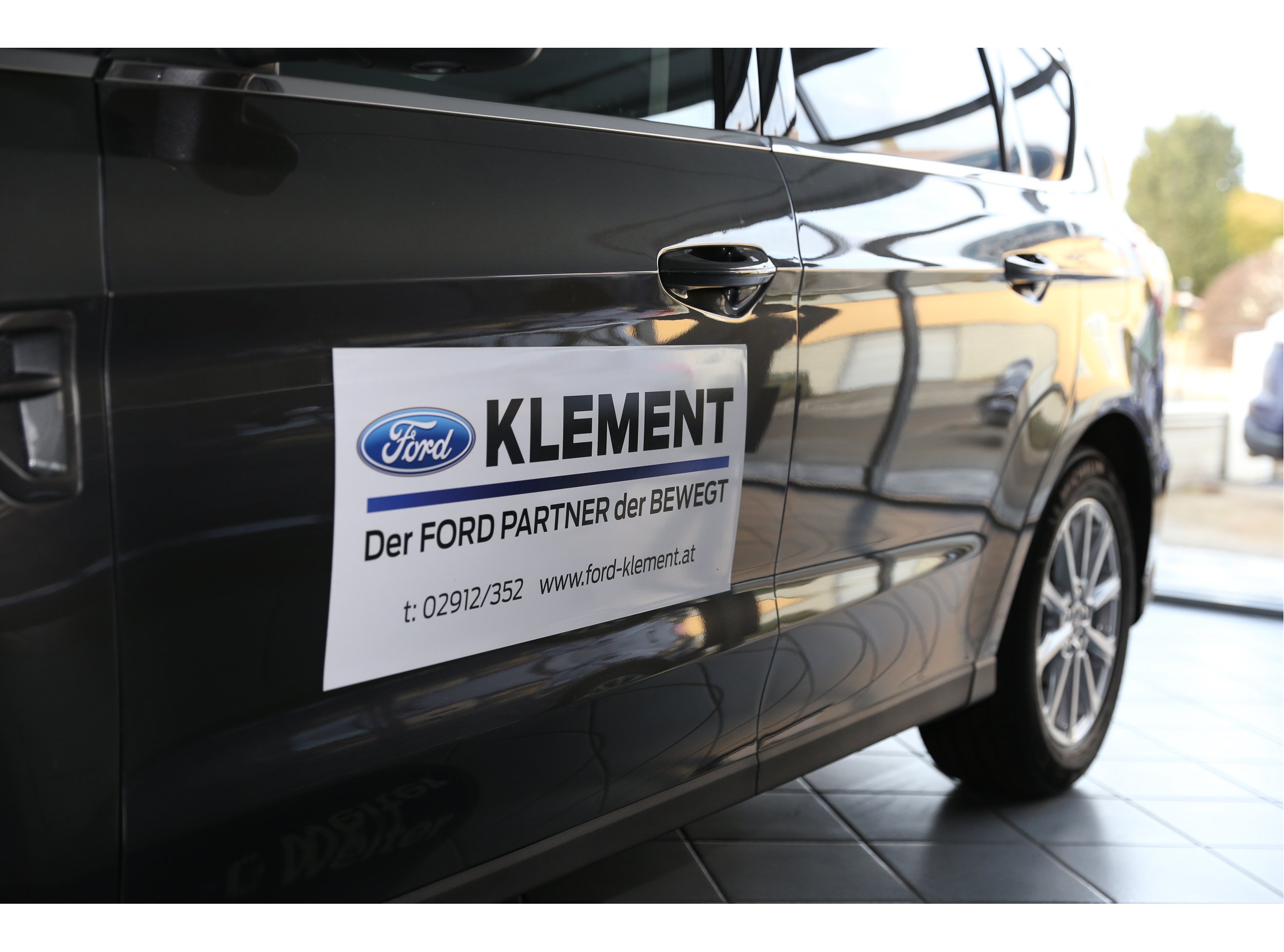 Seitenansicht eines Ford Fahrzeugs mit dem Logo und der Werbung für die Firma Klement.