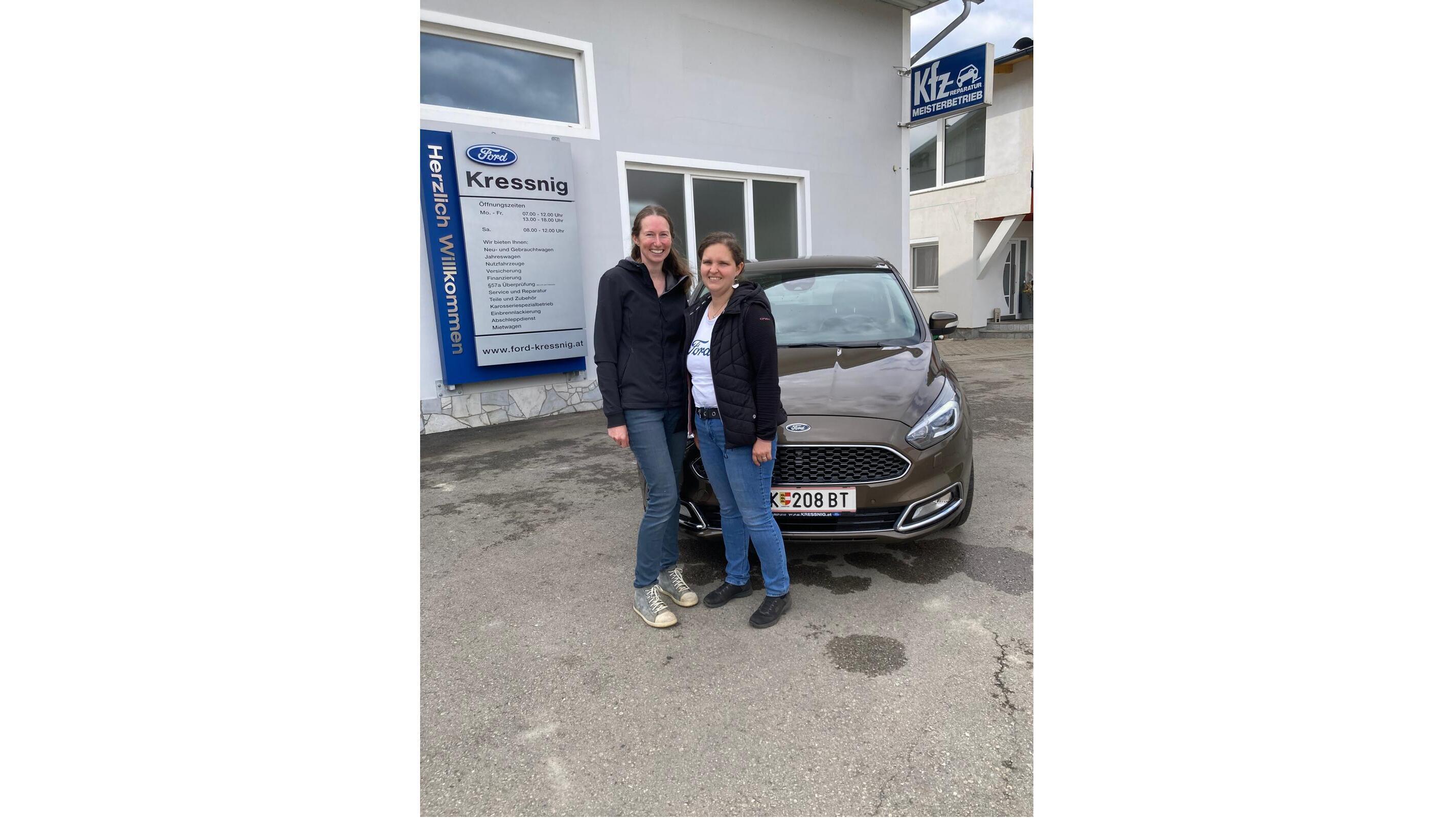 Zwei Frauen stehen neben einem braunen Ford vor einem Autohaus mit dem Namen Kressnig.