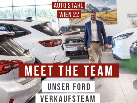 Autos in einem Verkaufsraum bei Auto Stahl in Wien 22, mit einem Mitarbeiter, der das Verkaufsteam präsentiert.