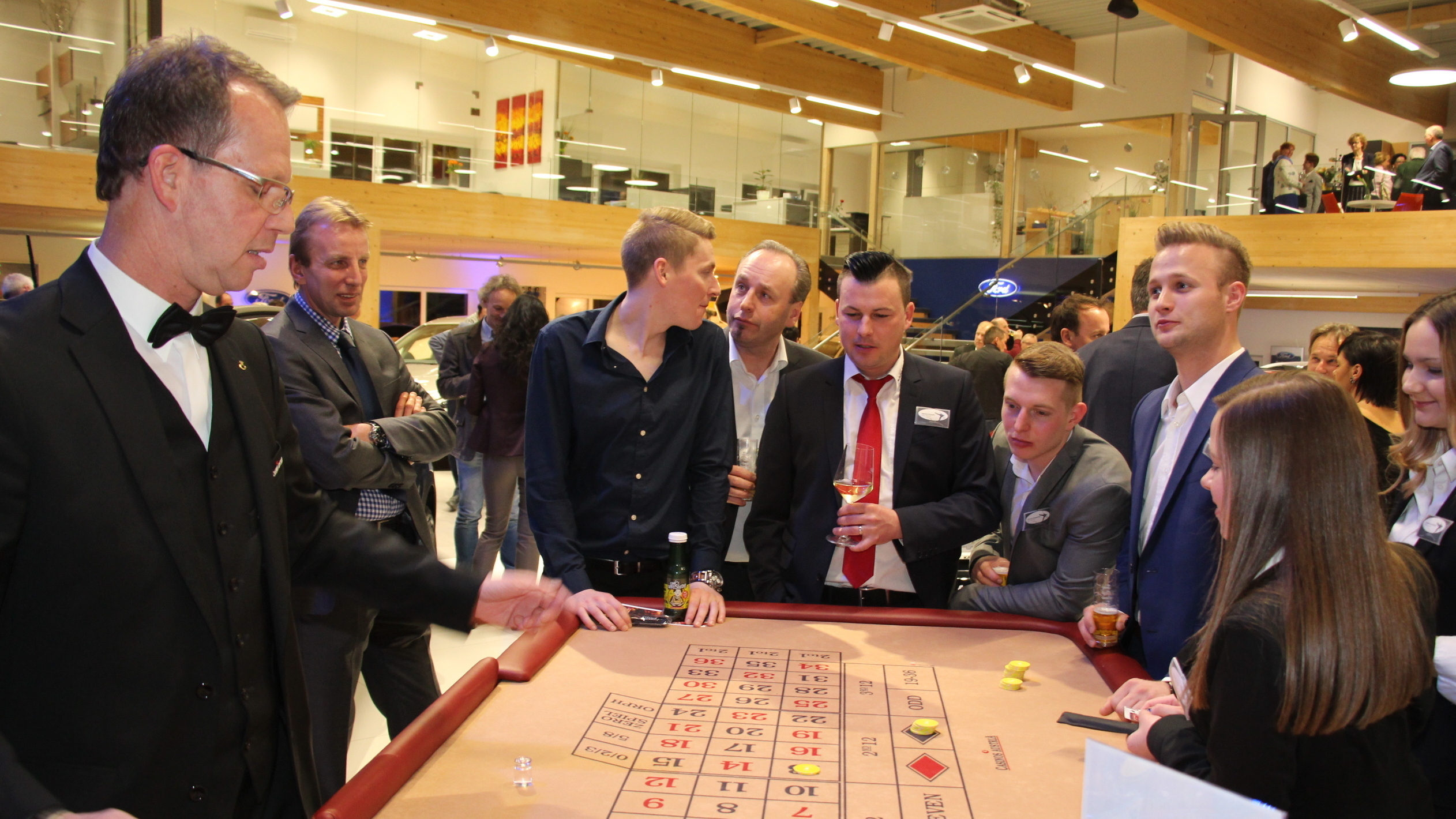 Ein Roulette-Spiel mit Spielern in formeller Kleidung, die von einem Croupier beraten werden.